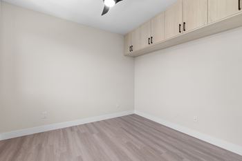 A room with wooden flooring and a cabinet on the wall.